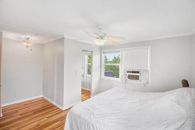 bedroom featuring attic access, crown molding, baseboards, and wood finished floors