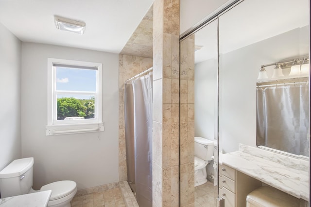 full bath featuring a tile shower, vanity, and toilet