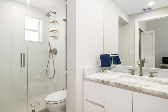 bathroom with visible vents, a stall shower, toilet, and vanity