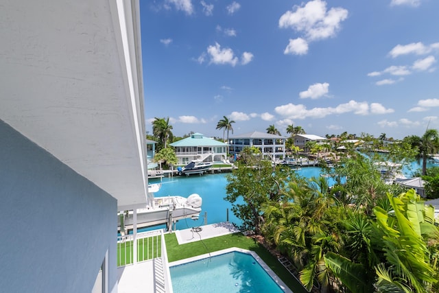 outdoor pool featuring boat lift, a water view, and a boat dock