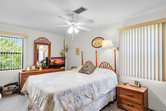bedroom featuring a ceiling fan, dark carpet, and visible vents