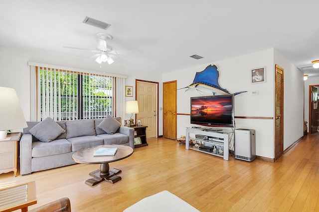 living area featuring visible vents, a ceiling fan, and wood finished floors