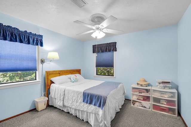 carpeted bedroom with baseboards, visible vents, and ceiling fan