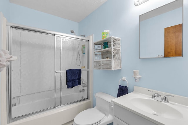 full bathroom with combined bath / shower with glass door, toilet, and vanity