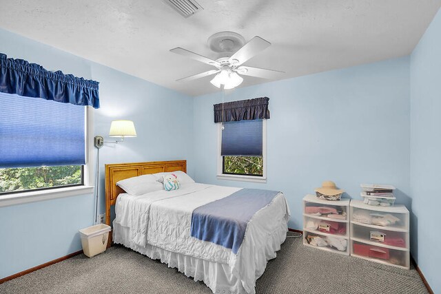 bedroom featuring baseboards, visible vents, carpet flooring, and a ceiling fan