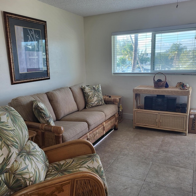 tiled living room with a textured ceiling and baseboards