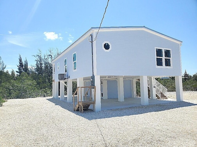 231 Pelican Ln, Big Pine, FL 33043 - rear view of house with a patio area, driveway, a carport, and stairway