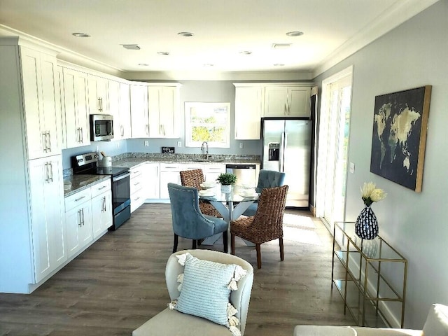 231 Pelican Ln, Big Pine, FL 33043 - kitchen with dark wood-style floors, stainless steel appliances, dark stone countertops, a sink, and white cabinetry