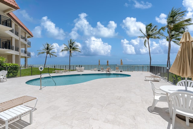 pool with a patio area and fence