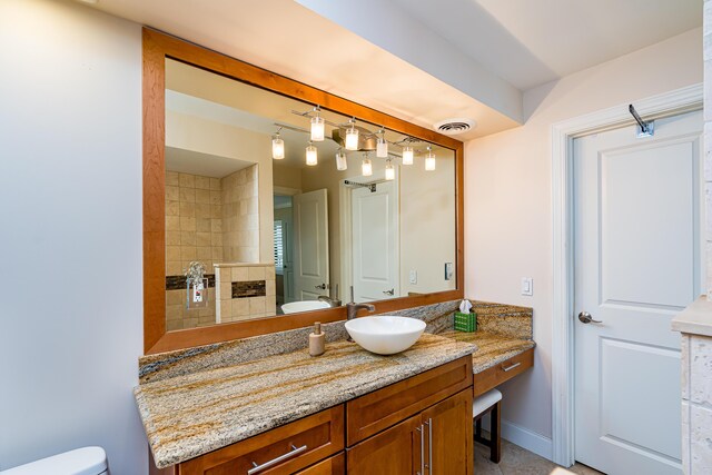 bathroom with visible vents, a tiled fireplace, toilet, a tile shower, and vanity
