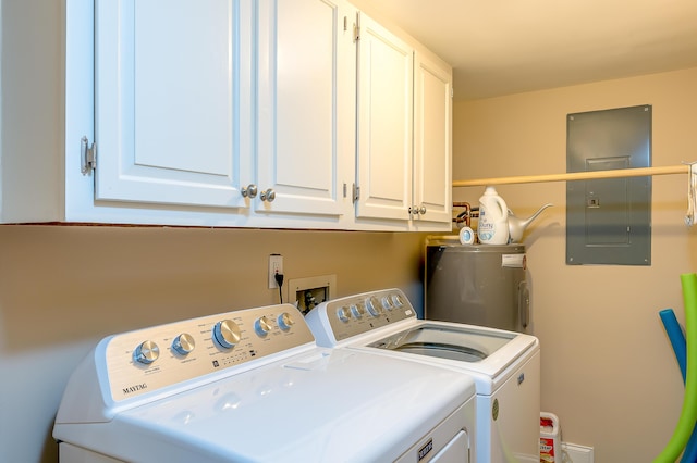 laundry room featuring electric panel, water heater, washing machine and clothes dryer, and cabinet space