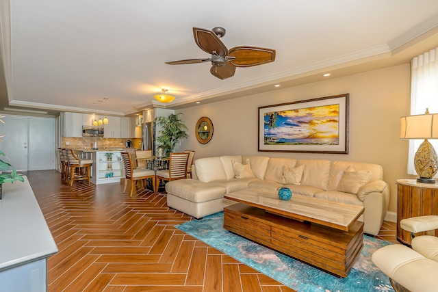 living area with recessed lighting, a tray ceiling, a ceiling fan, and crown molding