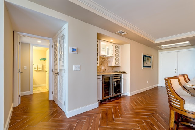 bar featuring a bar, visible vents, baseboards, and wine cooler