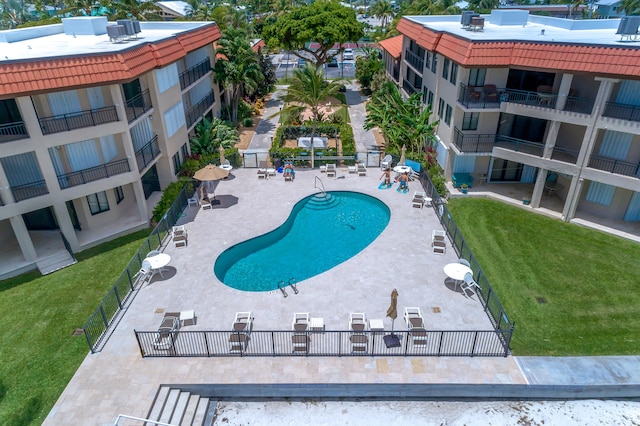 pool with a yard, fence, cooling unit, and a patio area