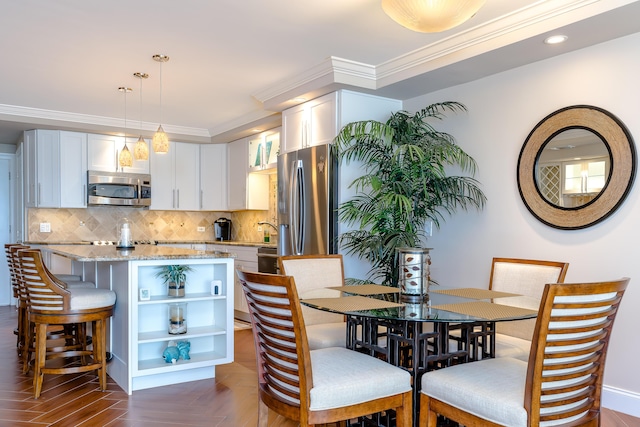 dining room with ornamental molding and recessed lighting