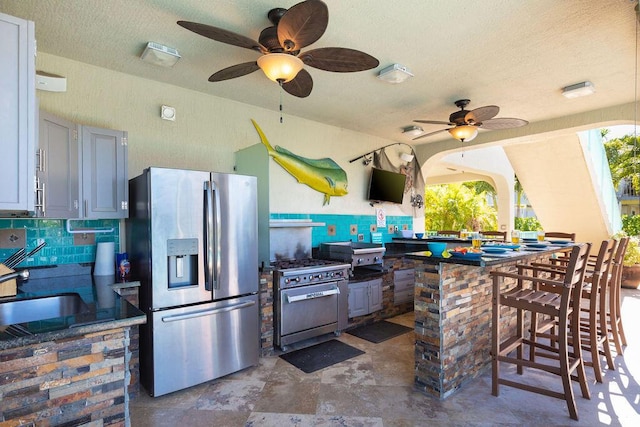 view of patio / terrace with outdoor wet bar, a sink, an outdoor kitchen, and a ceiling fan