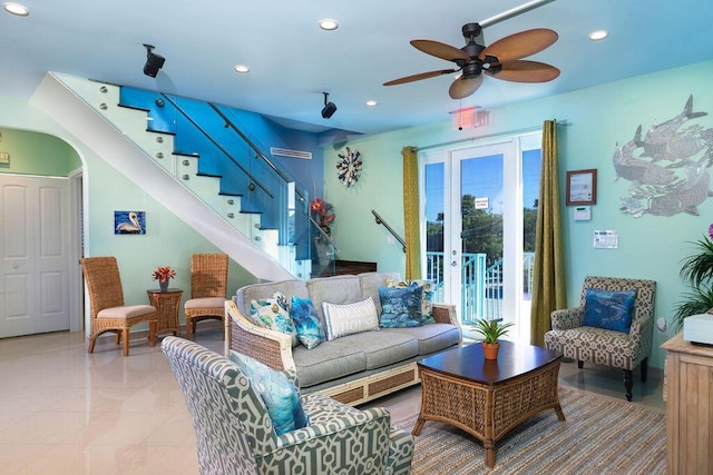 living area with arched walkways, recessed lighting, a ceiling fan, stairs, and tile patterned floors