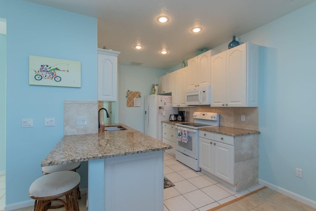 461 3rd St, Key Colony, FL 33051 - kitchen with white appliances, a sink, a breakfast bar, tasteful backsplash, and recessed lighting
