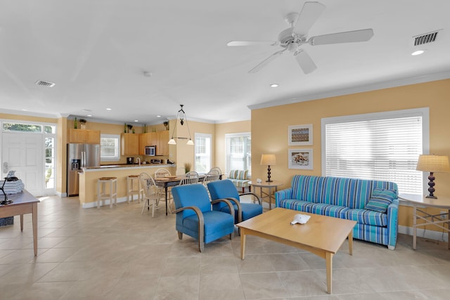 living room with light tile patterned floors, baseboards, visible vents, crown molding, and recessed lighting