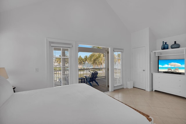 bedroom with access to exterior, multiple windows, high vaulted ceiling, and light tile patterned floors