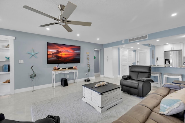 living area with ceiling fan, recessed lighting, visible vents, built in features, and baseboards