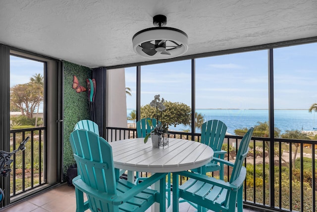 sunroom featuring a water view