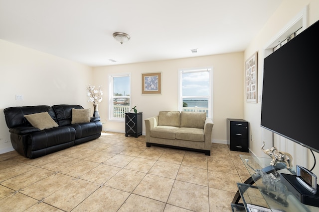 living room featuring light tile patterned floors, visible vents, and baseboards