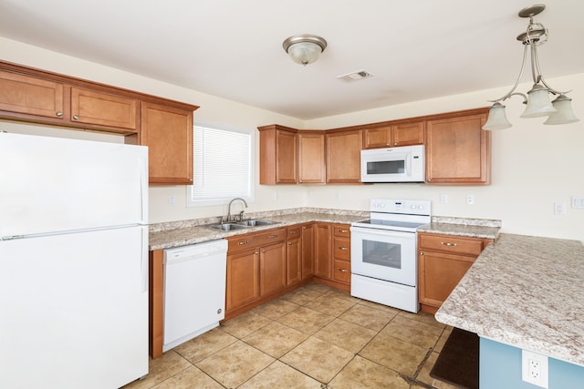 kitchen with visible vents, light countertops, brown cabinetry, white appliances, and a sink