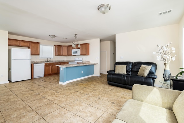 kitchen with visible vents, open floor plan, a peninsula, white appliances, and a sink