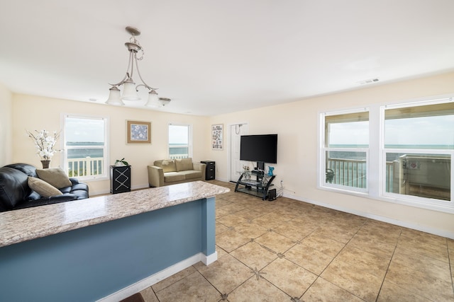 kitchen featuring light tile patterned floors, visible vents, pendant lighting, and open floor plan