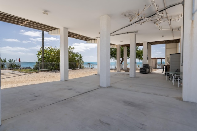 view of patio featuring fence and a water view