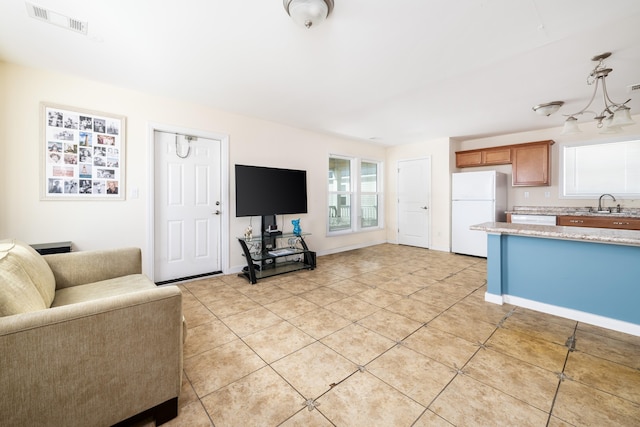 living area featuring light tile patterned floors, baseboards, and visible vents