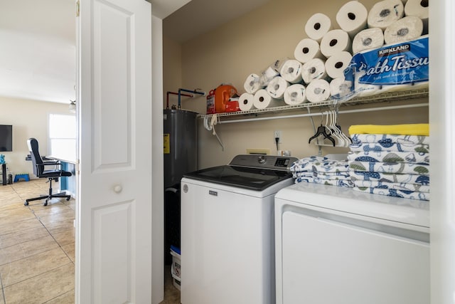 laundry room featuring light tile patterned floors, water heater, laundry area, and washing machine and clothes dryer