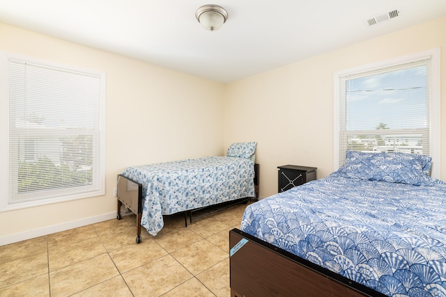 bedroom with tile patterned flooring, visible vents, multiple windows, and baseboards