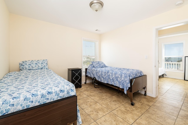 bedroom with light tile patterned floors, visible vents, and baseboards