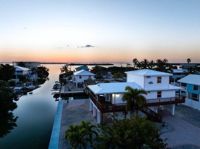 aerial view at dusk featuring a water view