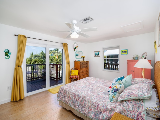 bedroom with visible vents, multiple windows, attic access, and access to outside