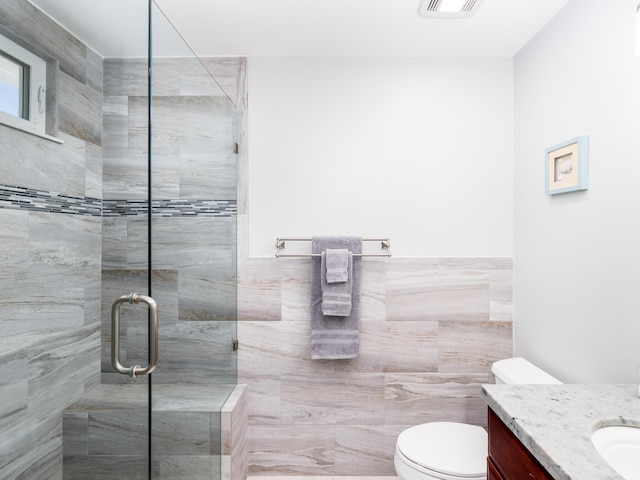 full bathroom featuring visible vents, a shower stall, tile walls, toilet, and vanity