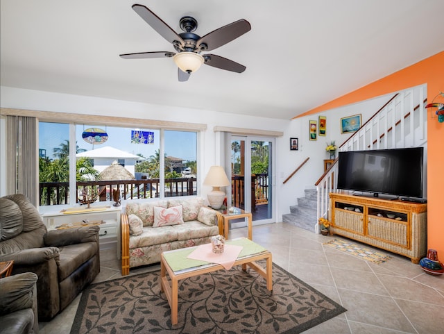 tiled living area with stairs, ceiling fan, and vaulted ceiling