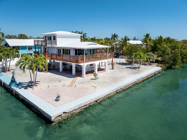 back of property featuring a balcony, a patio area, and a deck with water view