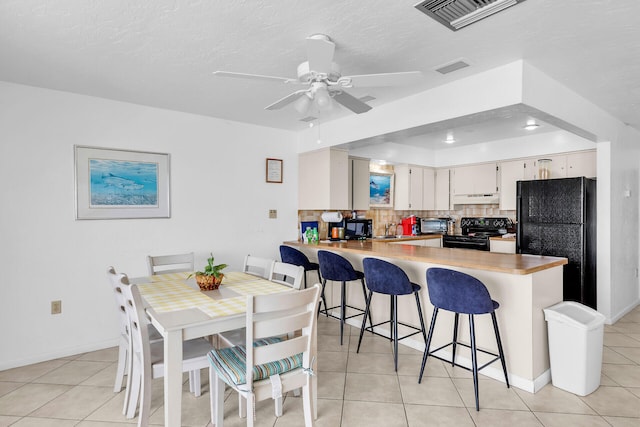5019THST & St, Key Colony, FL 33051 - kitchen featuring black appliances, under cabinet range hood, a sink, a peninsula, and light tile patterned floors