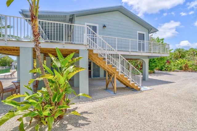 17126 Wahoo Ln, Sugarloaf, FL 33042 - back of property featuring stairs, a wooden deck, and a patio