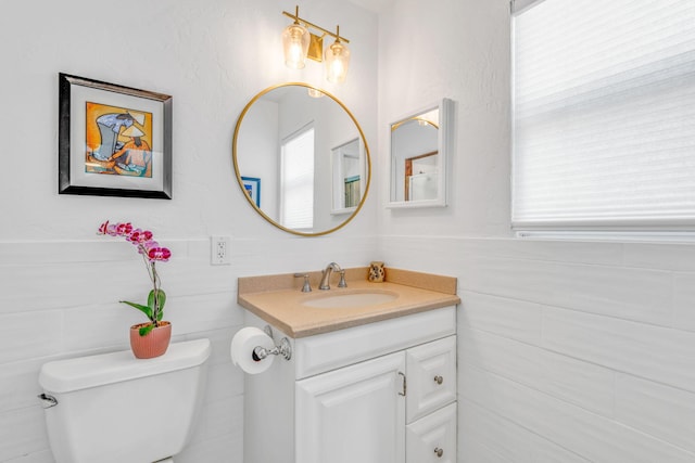 17126 Wahoo Ln, Sugarloaf, FL 33042 - bathroom featuring toilet, vanity, tile walls, and a wainscoted wall