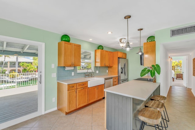 17126 Wahoo Ln, Sugarloaf, FL 33042 - kitchen with a sink, appliances with stainless steel finishes, a kitchen bar, light countertops, and light tile patterned flooring