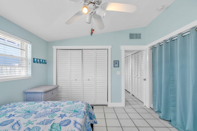 bedroom with light tile patterned floors, visible vents, lofted ceiling, ceiling fan, and a closet