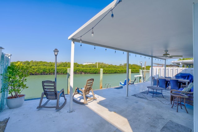 view of patio with a water view and a ceiling fan