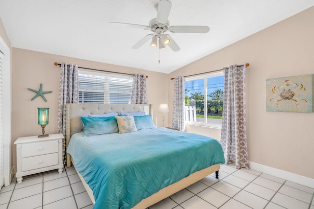bedroom with light tile patterned floors, a ceiling fan, baseboards, and vaulted ceiling