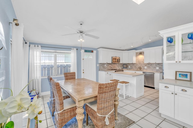 dining room featuring lofted ceiling, light tile patterned flooring, and a ceiling fan