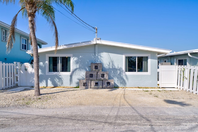 view of front of house with stucco siding and fence
