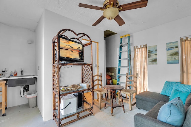 sitting room featuring concrete floors, a textured ceiling, and a ceiling fan